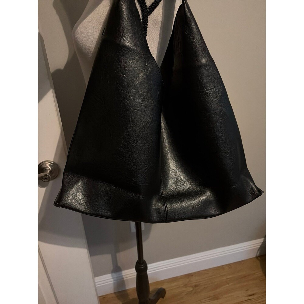Black slouchy vegan leather shoulder bag with an unstructured, triangular hobo d